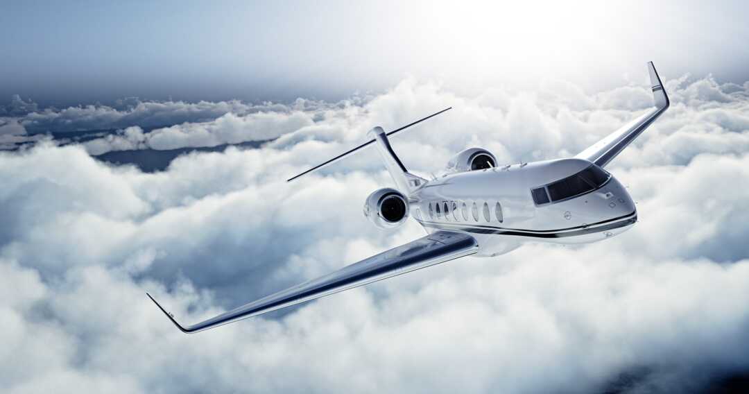 Luxury private jet soaring through a clear blue sky.