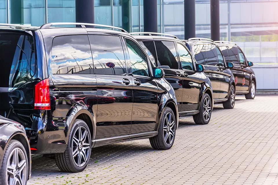 Black Mercedes-Benz V-Class minivan parked at an Event, rear side view.