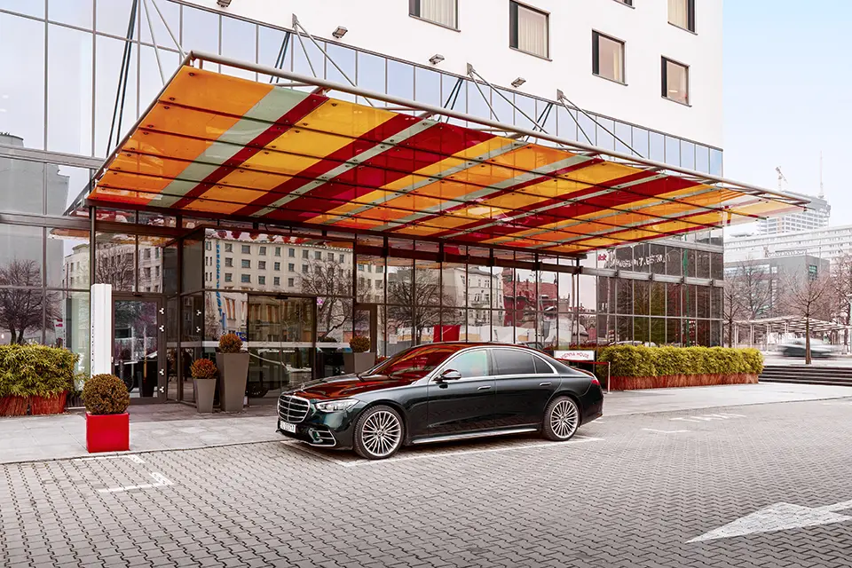 Luxury mercedes s-class parked in a hotel driveway, representing premium hotel transfer service