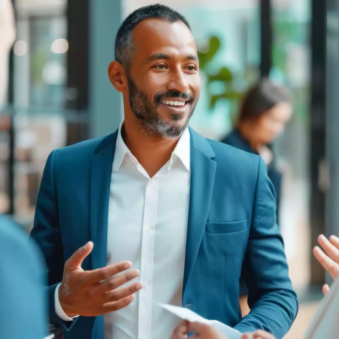 Business professionals engaging in a lively discussion in a modern office, illustrating HYRYDE’s Global Chauffeur Network for executive travel solutions