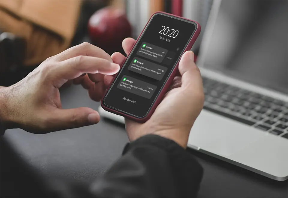 Young businessman working late, using a smartphone in a dark modern office