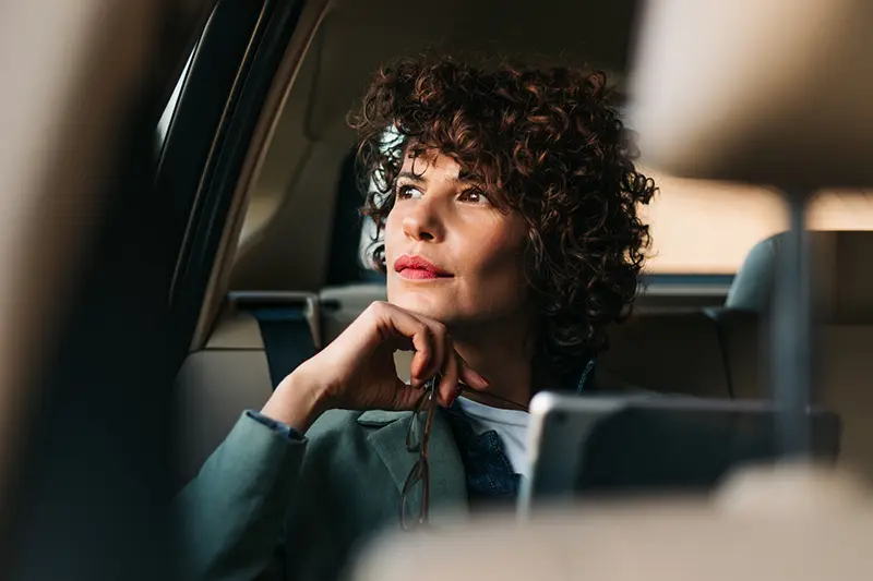 Business Travel Chauffeur Service | Executive Passenger Experience Executive business traveller seated in a chauffeur-driven car during corporate travel journey